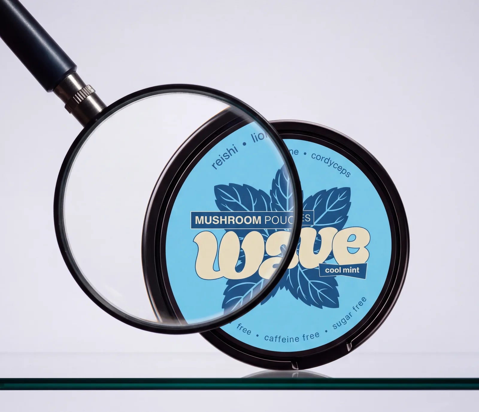 A magnifying glass over a Cool Mint WAVE can on a glass shelf
