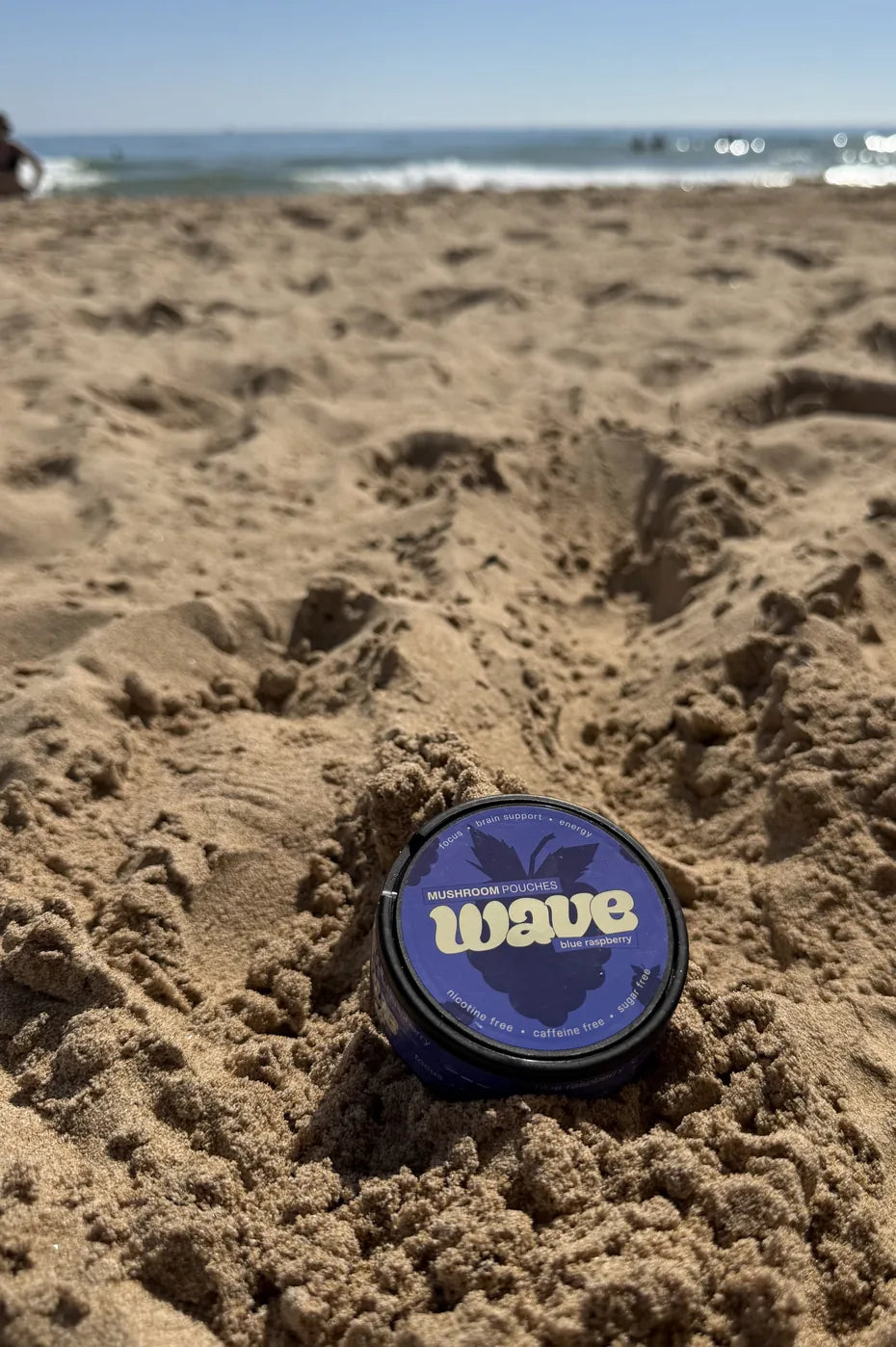 WAVE can lying in the sand on a beach