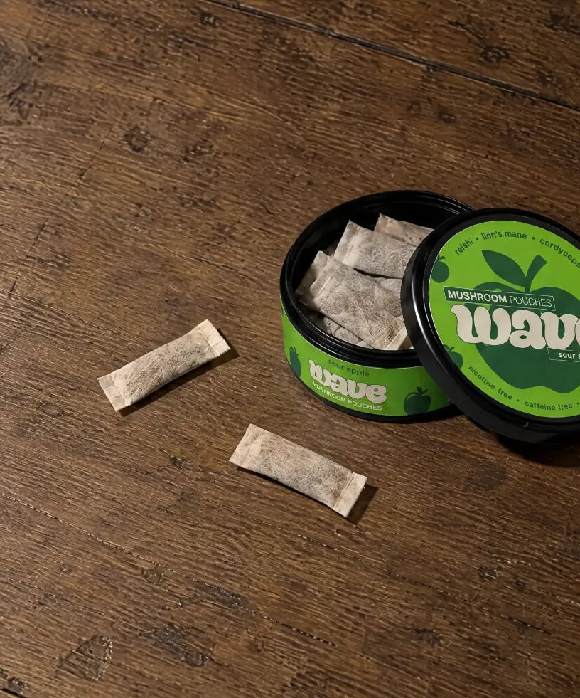 Open can of WAVE pouches on a wooden table with two pouches beside it