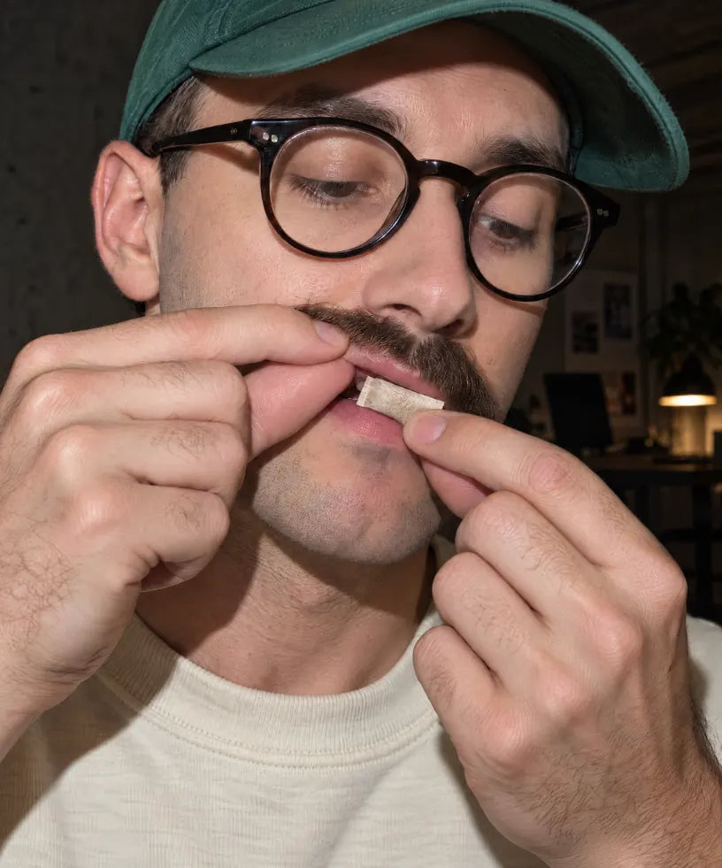 Man placing a WAVE pouch under his upper lip