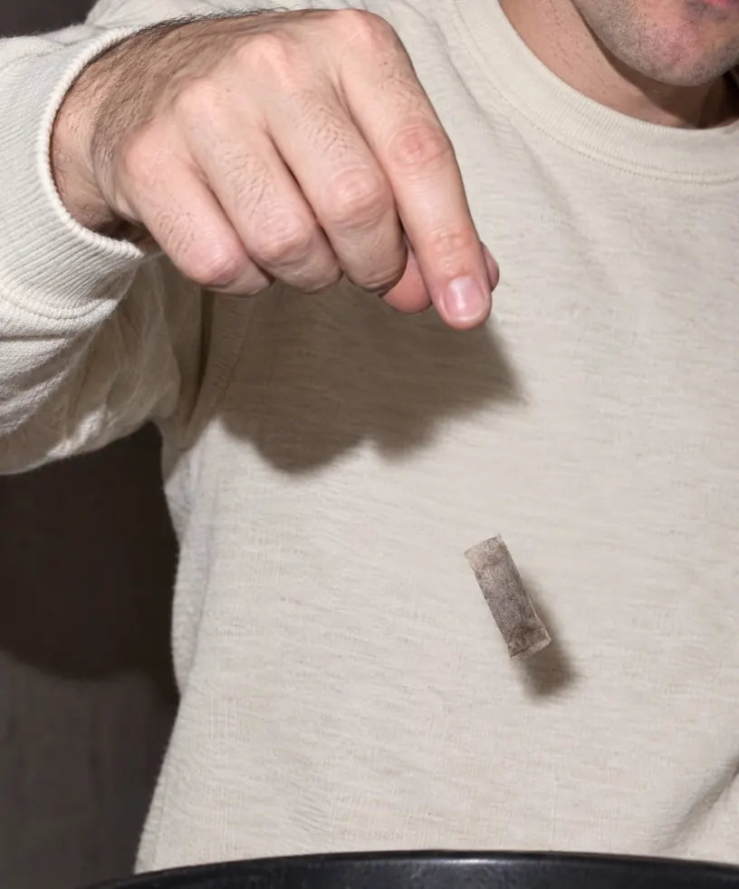 A used pouch being dropped into a bin